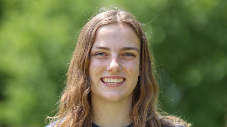 woman smiling in front of trees