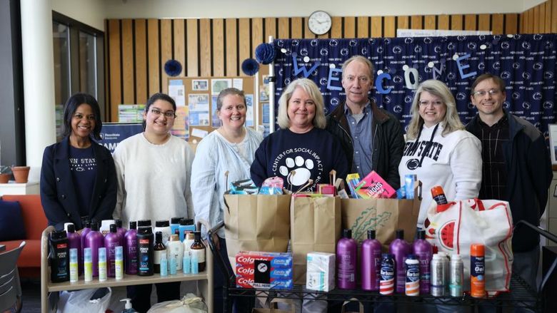 a group of people stand behind a display of toiletry items