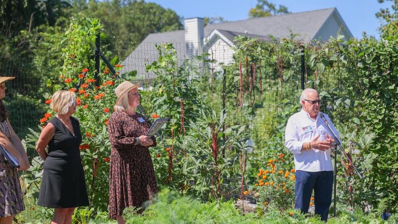 man speaking at microphone in garden