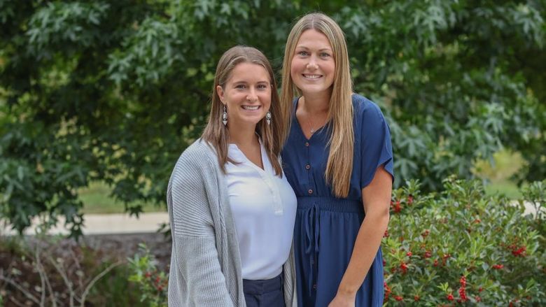 Two women pose for a photo outside on the Penn State Brandywine campus.