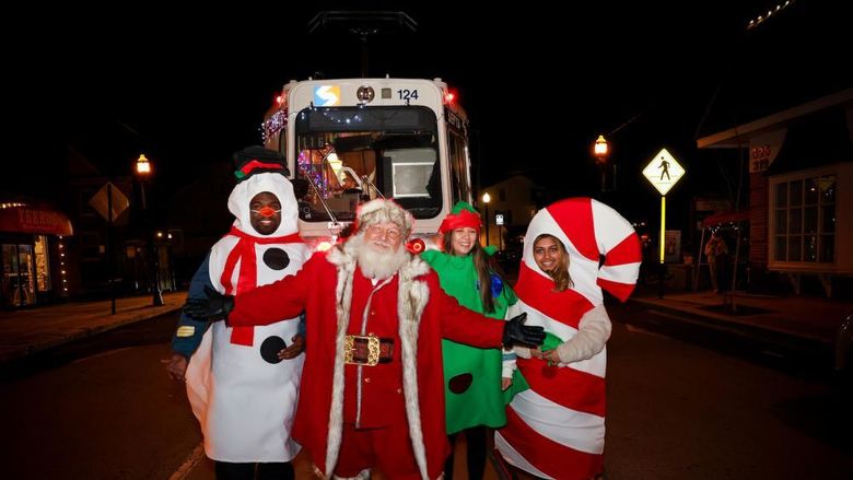 students in snowman, tree and candy cane costumes with Santa