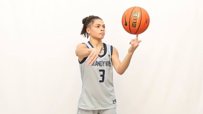 Jenaya Smith wearing Brandywine women's basketball jersey, number 3, spinning a basketball in her hand