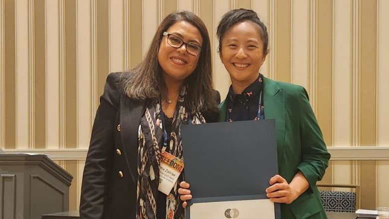 Terrie Wong holding certificate next to woman at National Communication Association conference