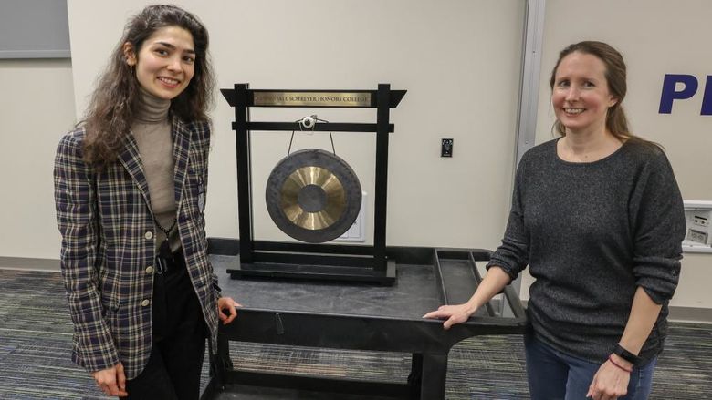 Anna and Nora standing with a gong