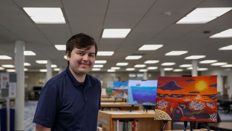 Jacob Campbell standing next to his painting