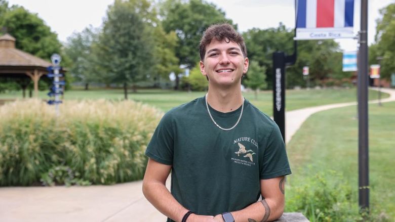 A male student stands on a sidewalk at Penn State Brandywine.