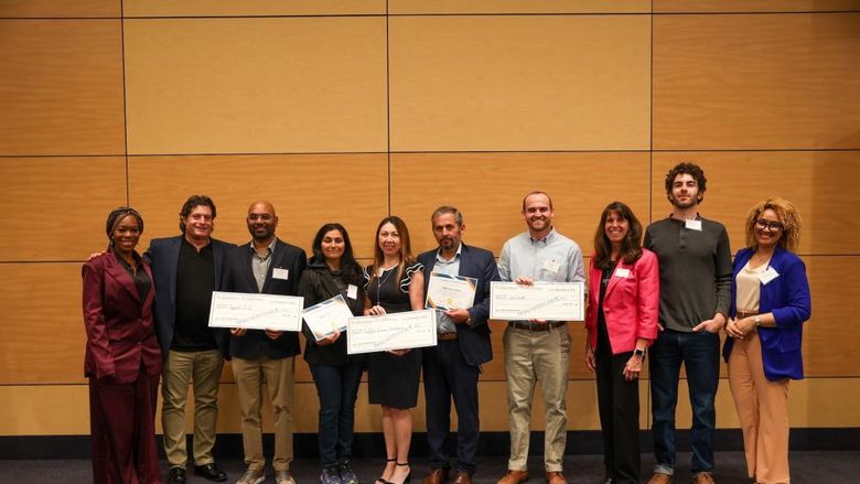 people holding large checks