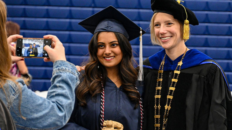 graduate and chancellor smiling for a photo