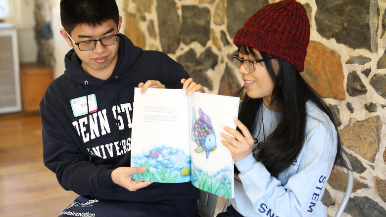 Penn State Brandywine students Eric Tseng and Anna Nguyen read to children at Tyler Arboretum.