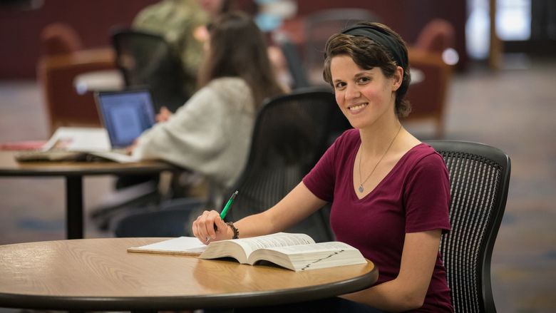 Catherine Mesure sitting in Penn State Brandywine's library. 
