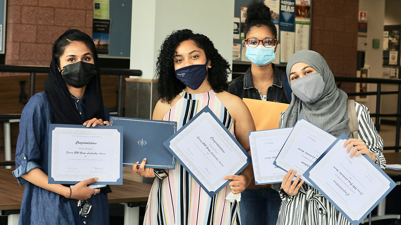 A group of female students sharing their award certificates.