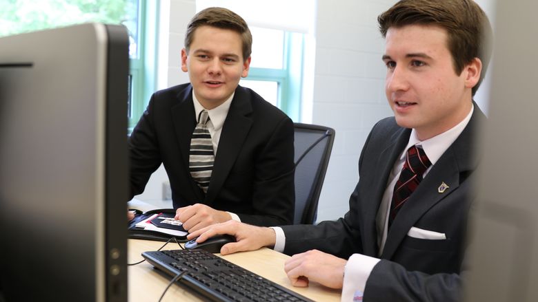 Students Coleman Hart and David Spencer compete at computer.