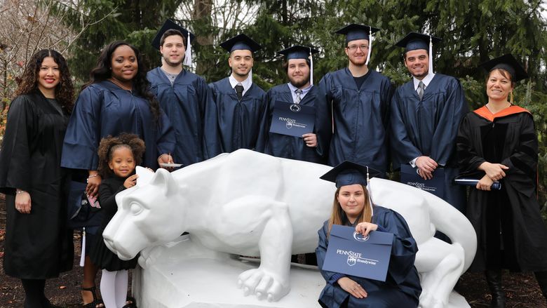 Students and faculty stand at the lion shrine