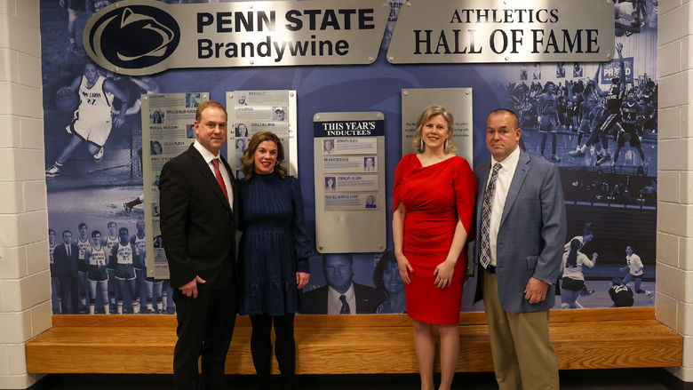 hall of fame inductees standing in front of hall of fame wall