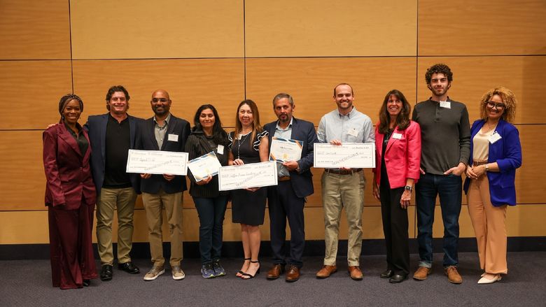 contestants holding large checks