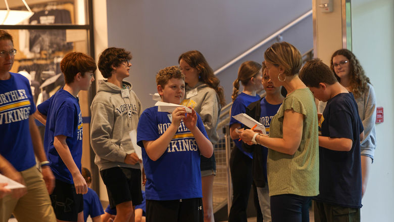 students flying paper airplanes