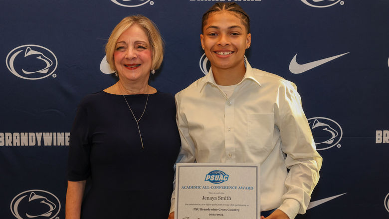 student holding award with Chancellor Wells