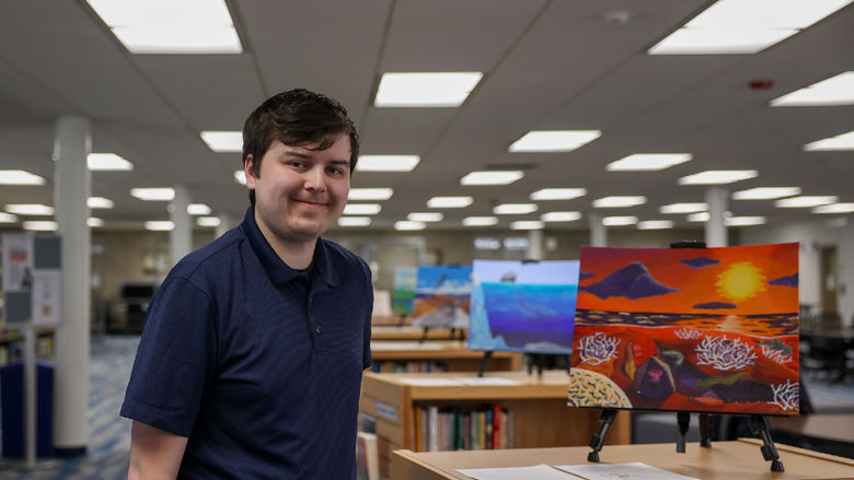 Jacob Campbell standing next to his painting