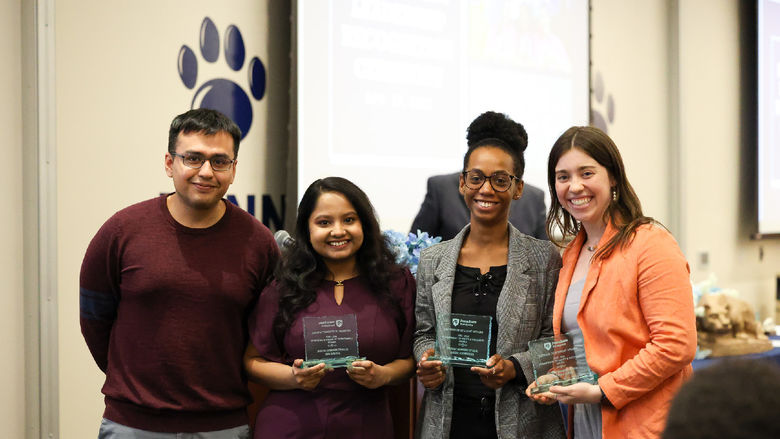 Three women accepting awards from a man