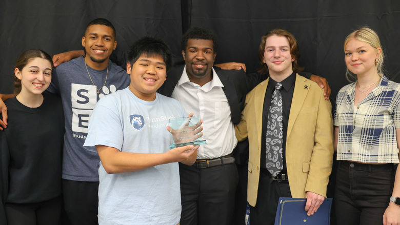 Six students smiling in front of a black backdrop