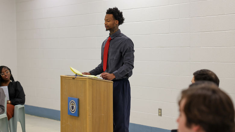 Dymir standing at a podium