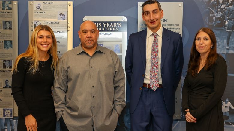 hall of fame inductees standing in front of hall of fame wall