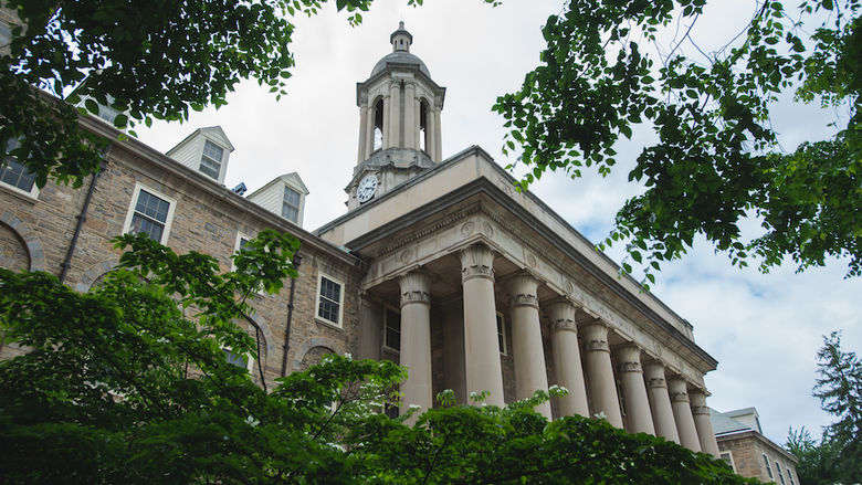 Photograph of Old Main surrounded by summer foliage