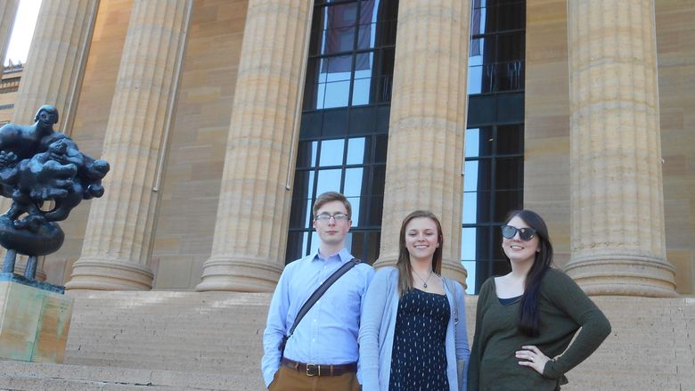 Students stand on steps outside art museum