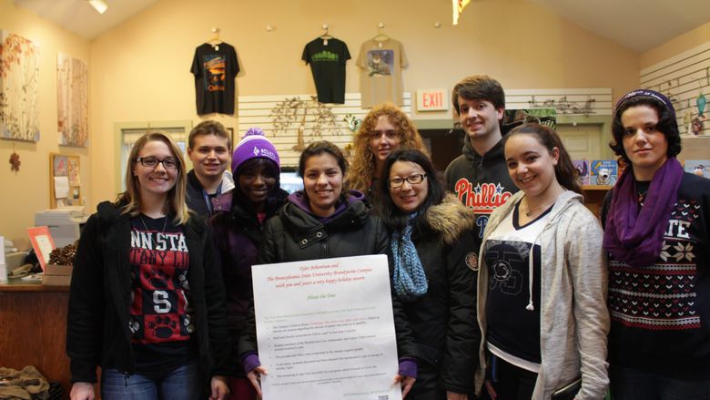 Students stand with sign explaing the project