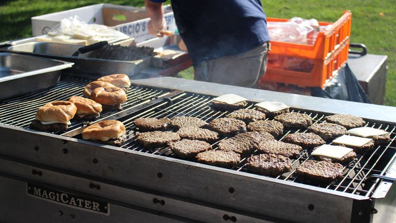 Photo of a grill with burgers.