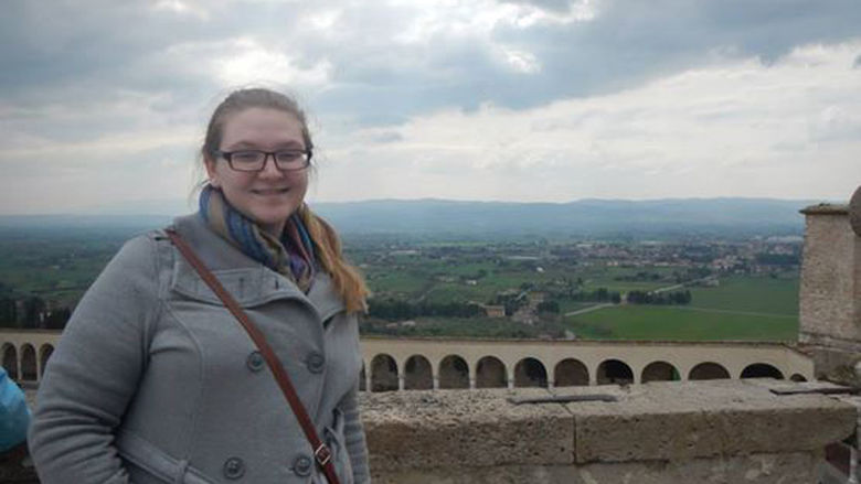 Megan Griffith standing in front of a bridge in Italy