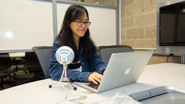 Anna Nguyen at Penn State Brandywine in front of a laptop. 