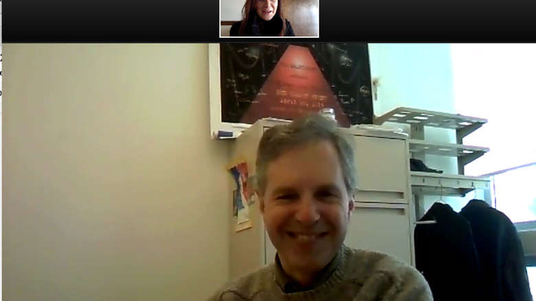 Online meeting tool Zoom screenshot showing person at desk talking to person in small inset screen.
