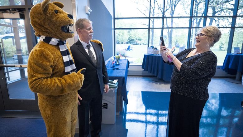 someone taking a photo of a person with the Nittany Lion