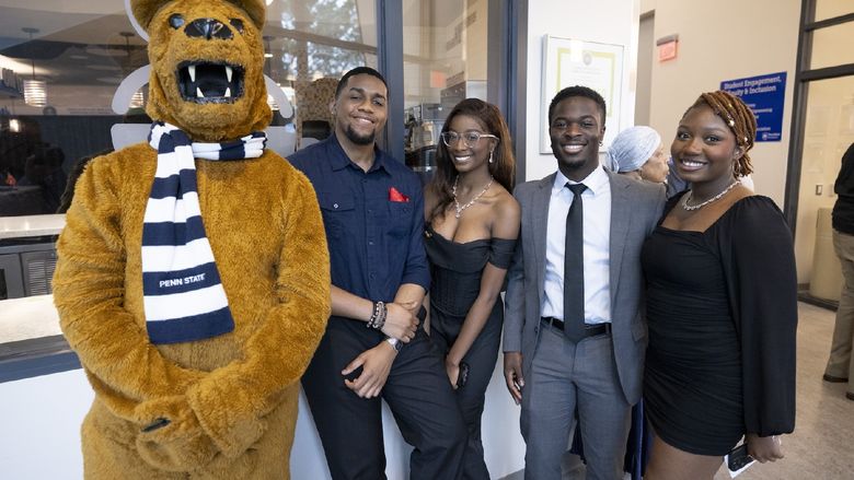 students standing with Nittany Lion