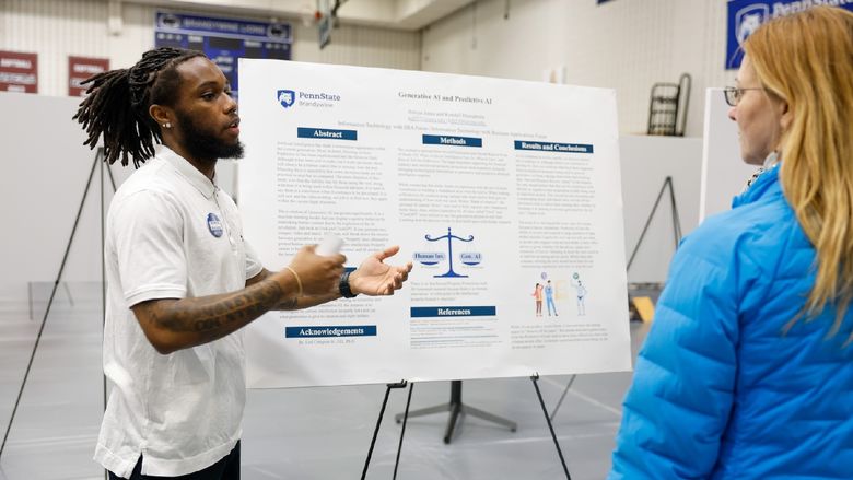 student presenting work on poster board
