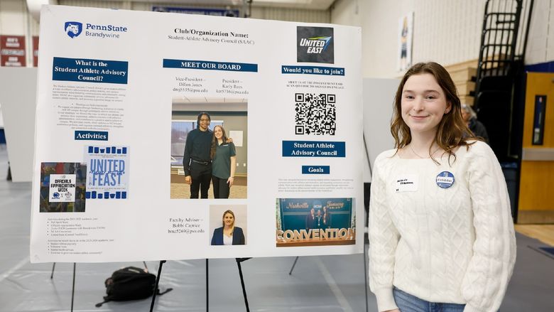 student presenting club on a poster
