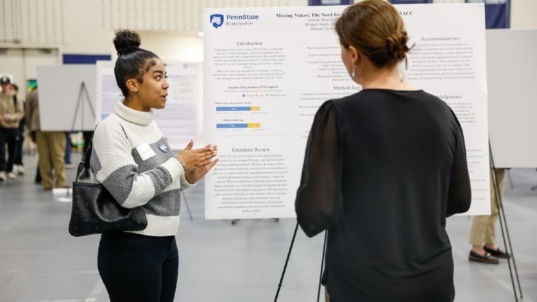 student presenting work on poster