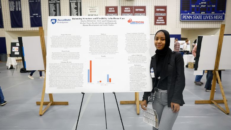 student presenting work on poster board