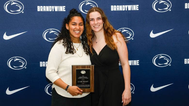 student and staff holding plaque