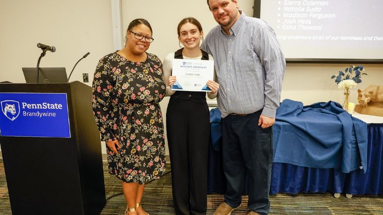 student and staff members with award