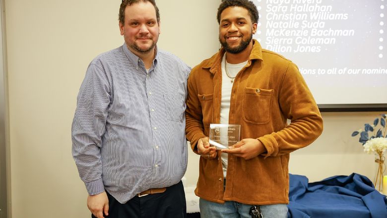 student with award and staff member