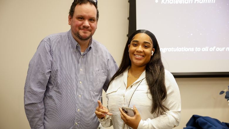 student and staff member with award