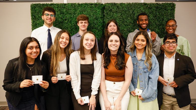 group of students holding necklaces
