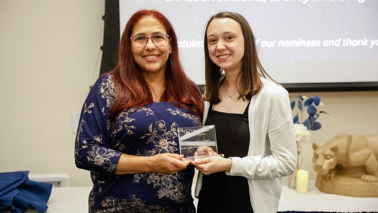 student and staff member with award