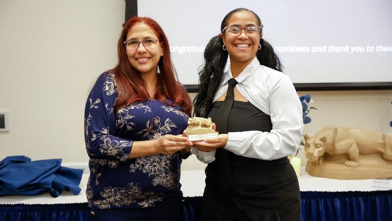 student and staff member with award