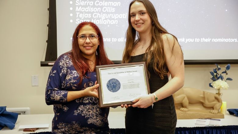 student and staff member with award
