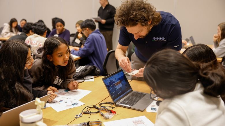 man helping students with workshop