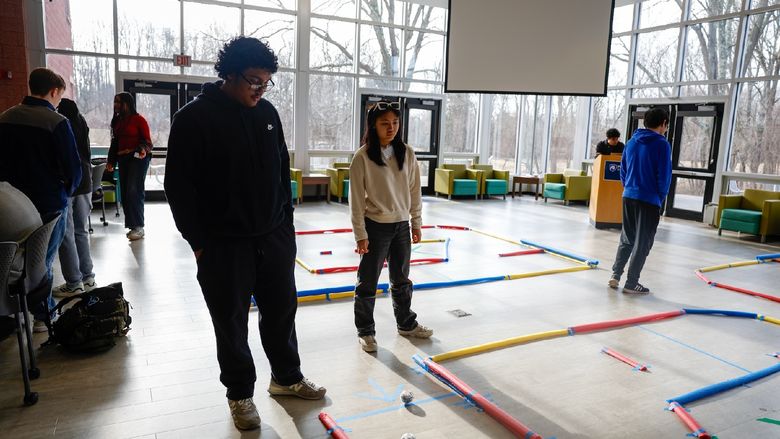 Students standing with robots