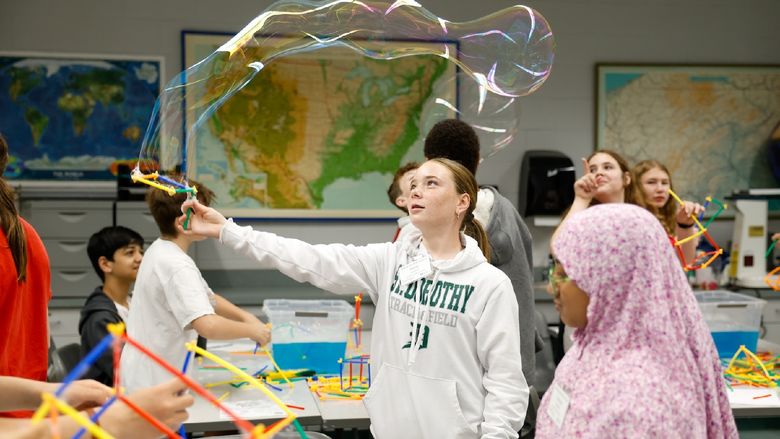 student waving bubble wand